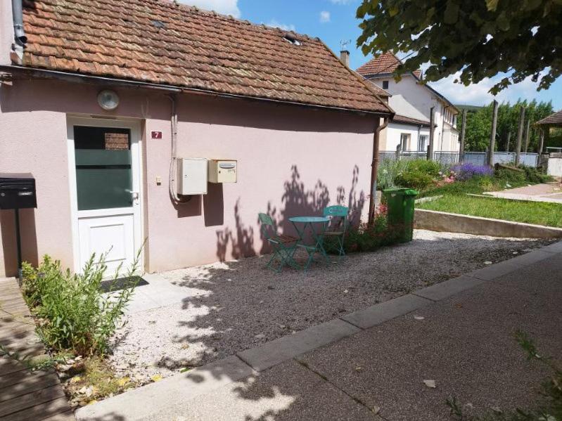 una casa rosa con un tavolo e sedie di fronte di Maison à Pouilly en Auxois a Pouilly-en-Auxois