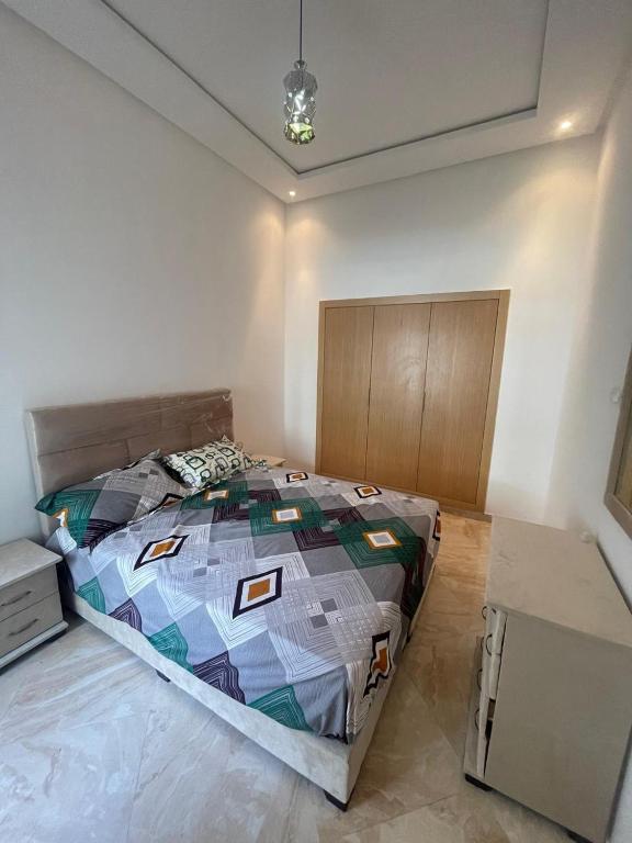 een slaapkamer met een groot bed in een kamer bij Kettani Bouznika Hind in Bouznika