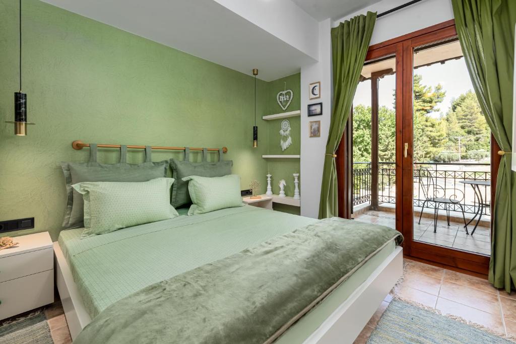 a bedroom with a large bed and a balcony at Lous House in Agia Paraskevi