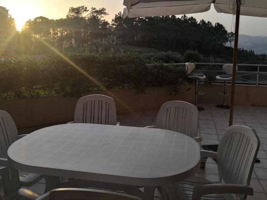 une table et des chaises blanches ainsi qu'un parasol dans l'établissement 2 bedroom apartment with large terrace, à Théoule-sur-Mer