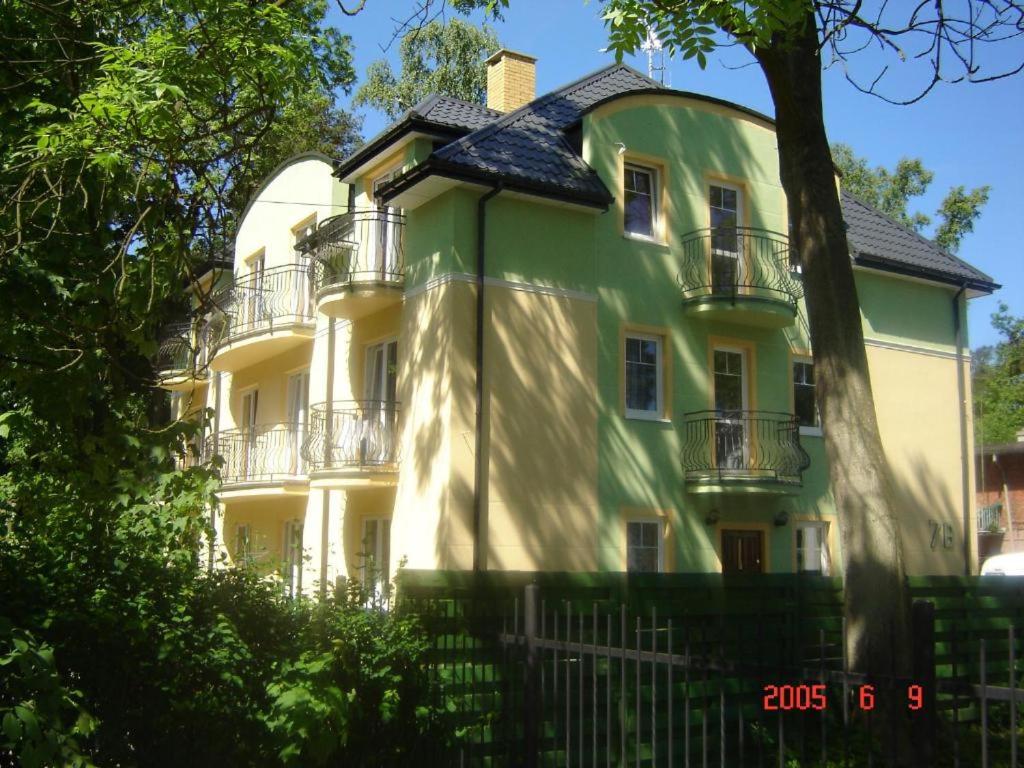 a large green and white house with a fence at Ambasador Villa, 150m do plaży, przy Centrum in Mielno