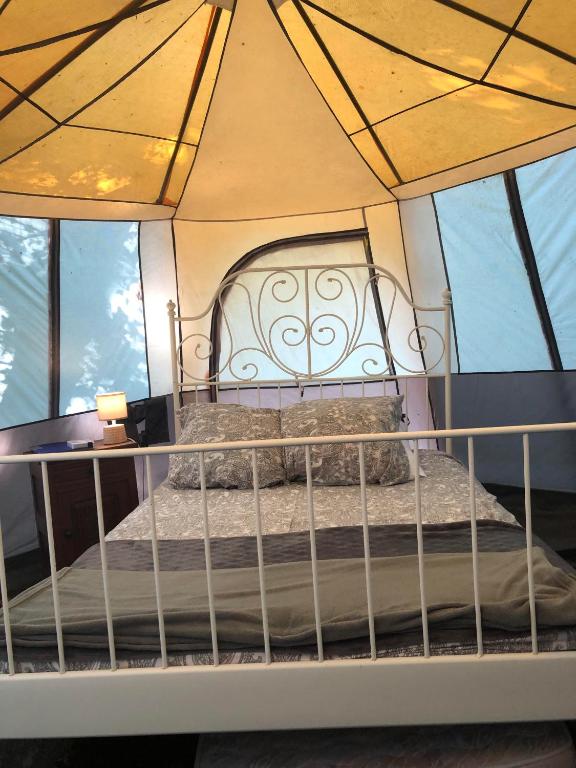 un lit dans une chambre avec une grande fenêtre dans l'établissement Camping Au Lac Du Drennec Glamping Tent, à Commana