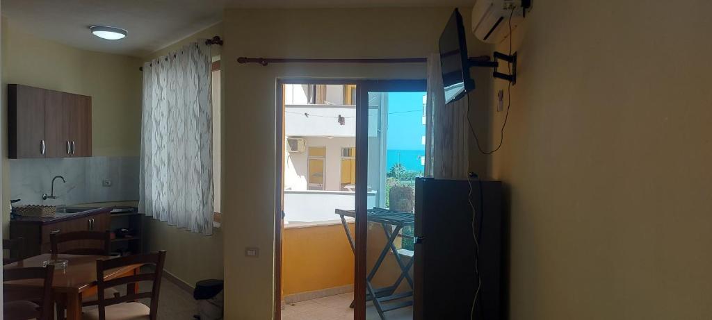 a kitchen with a sliding glass door to a window at Rigandi in Durrës