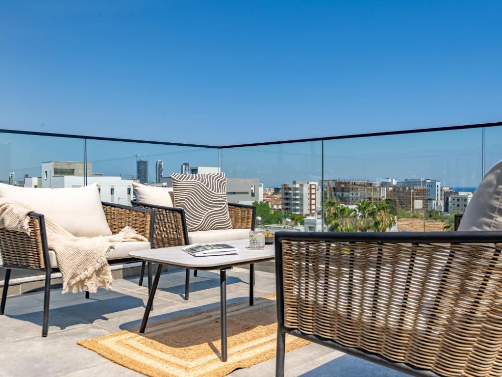a patio with chairs and a table on a balcony at Sanders Evolution 2 Limassol in Limassol