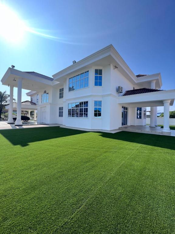 una gran casa blanca con un gran césped verde en DeGarden House Bangi, en Kajang