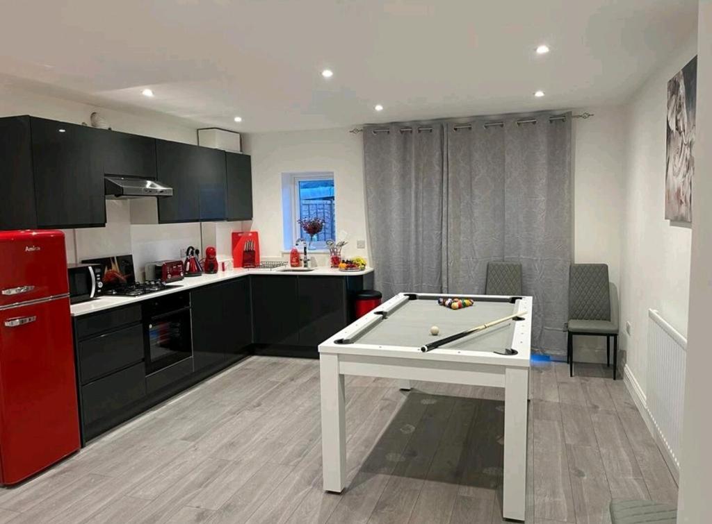 una cocina con mesa de ping pong. en JB Stays Therapia, en Hackbridge