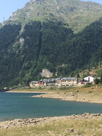 une maison à flanc de montagne près d'un plan d'eau dans l'établissement appartement vue sur lac, à Laruns