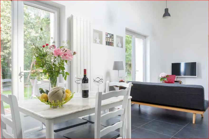 un salon avec une table avec un vase de fleurs dans l'établissement Charmante maison Les Glycines DisneyLand Paris, à Montry