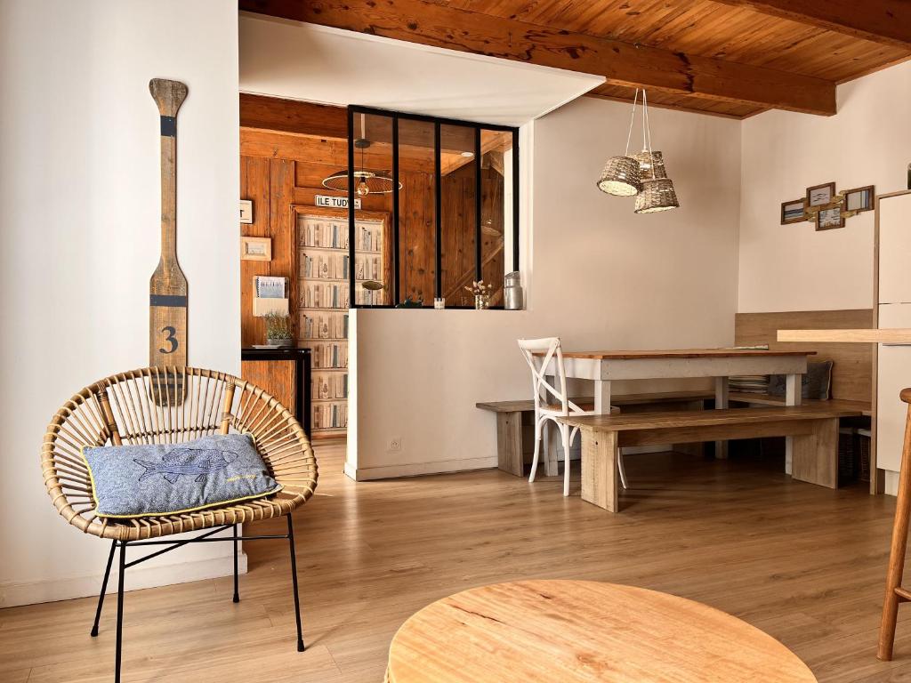 une cuisine et une salle à manger avec une chaise en rotin et une table dans l'établissement Jolie maison au port de l'île Tudy, à l'Île-Tudy