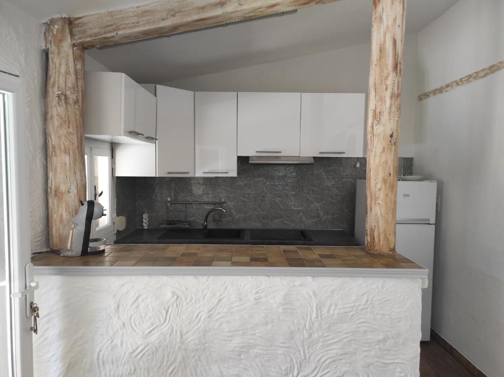 une cuisine avec des armoires blanches et un évier dans l'établissement Maison en campagne, à Pernes-les-Fontaines