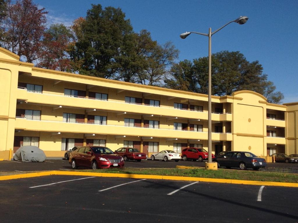 a parking lot with cars parked in front of a building at DIAMOND INN & SUITES in Richmond