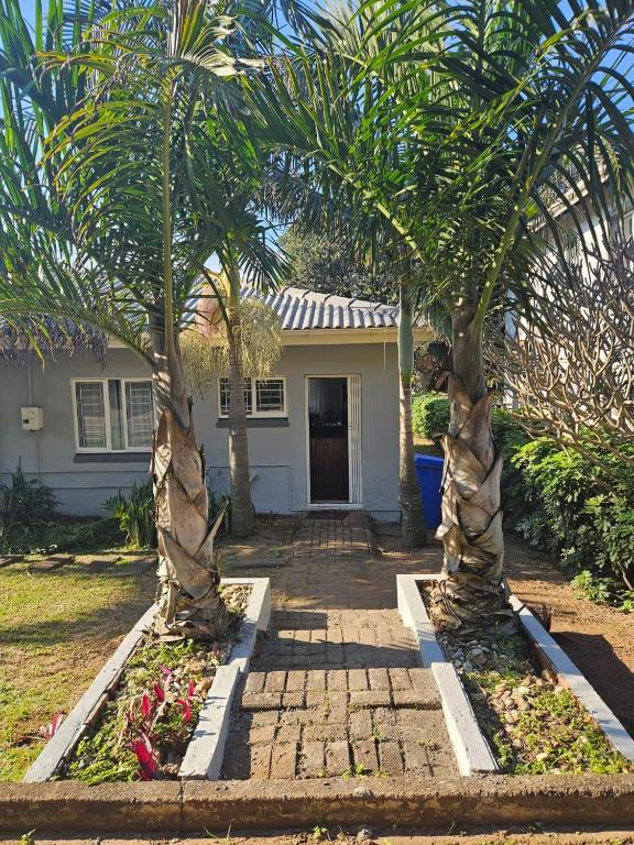 a house with two palm trees in front of it at Villa Rosseau in Freeland Park