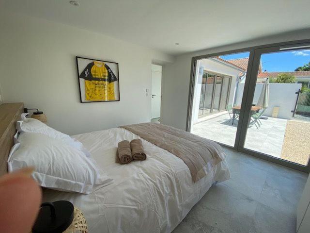 une chambre avec un lit avec deux pantoufles dessus dans l'établissement maison centre ville, à Lagord