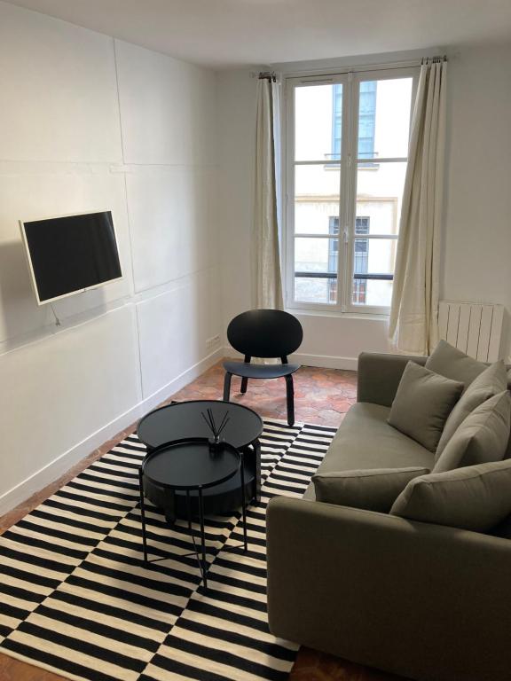 un salon avec un canapé et une table dans l'établissement L'atelier du château, à Versailles