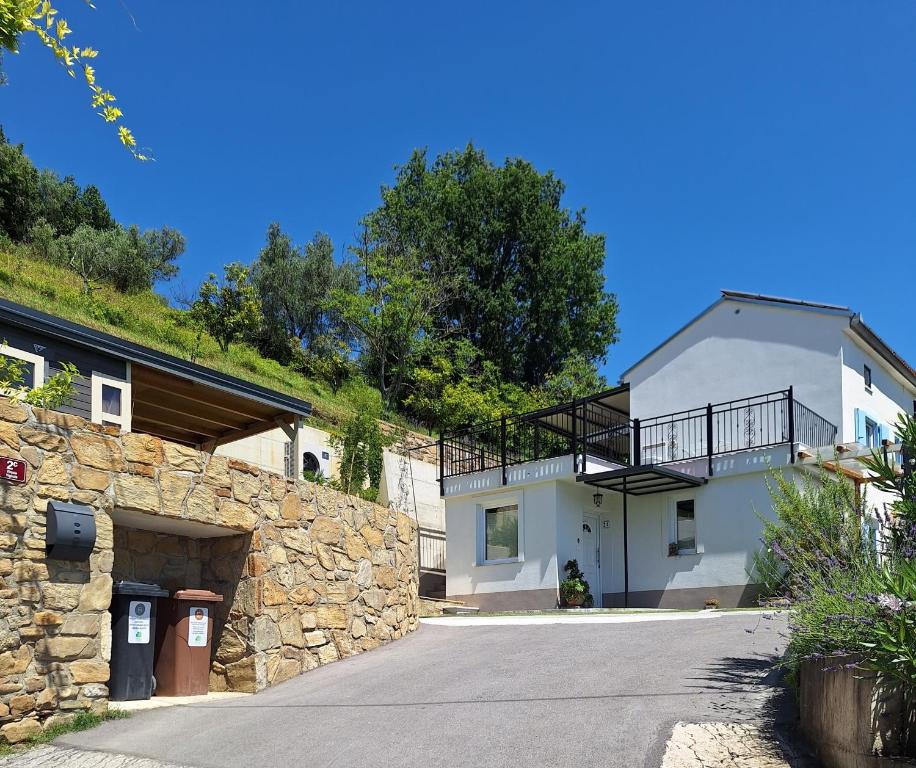 a house with a stone wall and a driveway at Apartment Vignole in Portorož