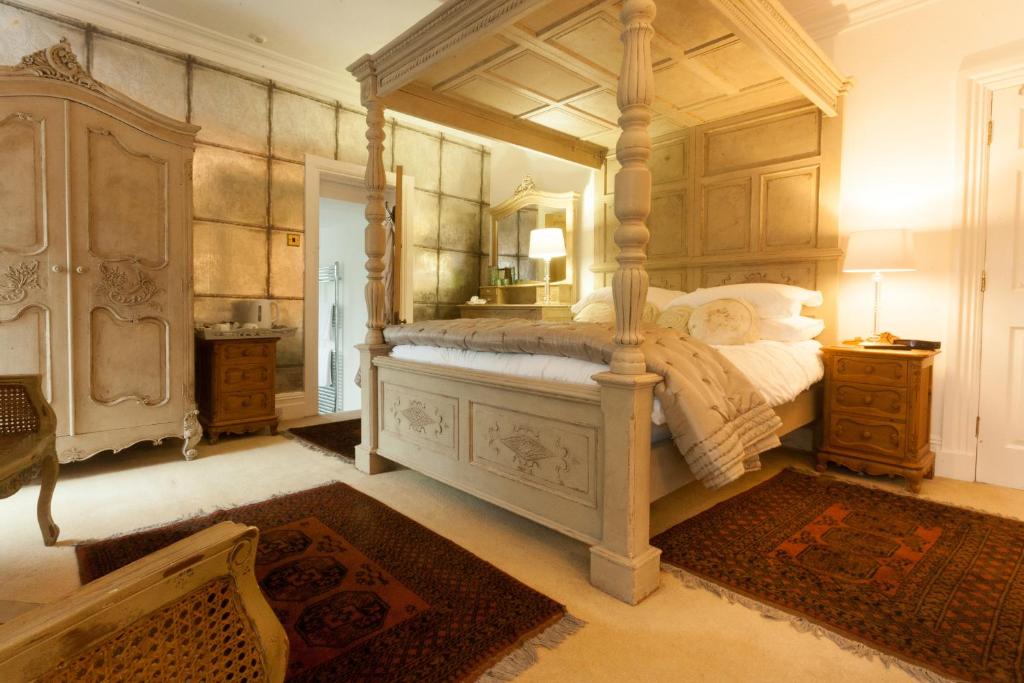 a bedroom with a large canopy bed with a mirror at Meifod House in Caernarfon