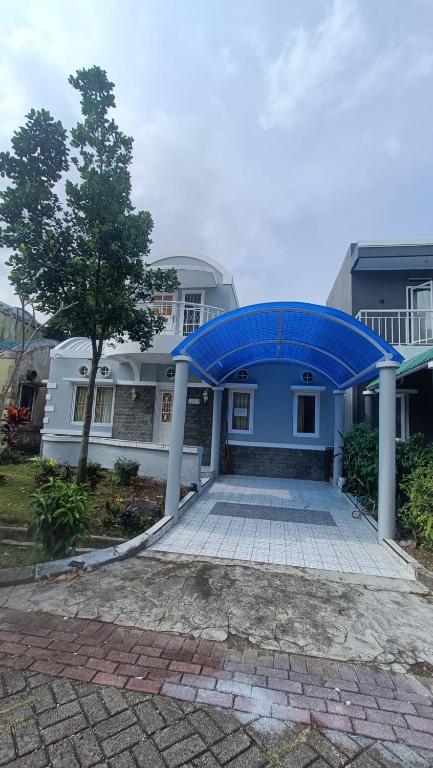 a blue house with a blue roof at Villa Dalia Puncak H1-26 in Cikundul