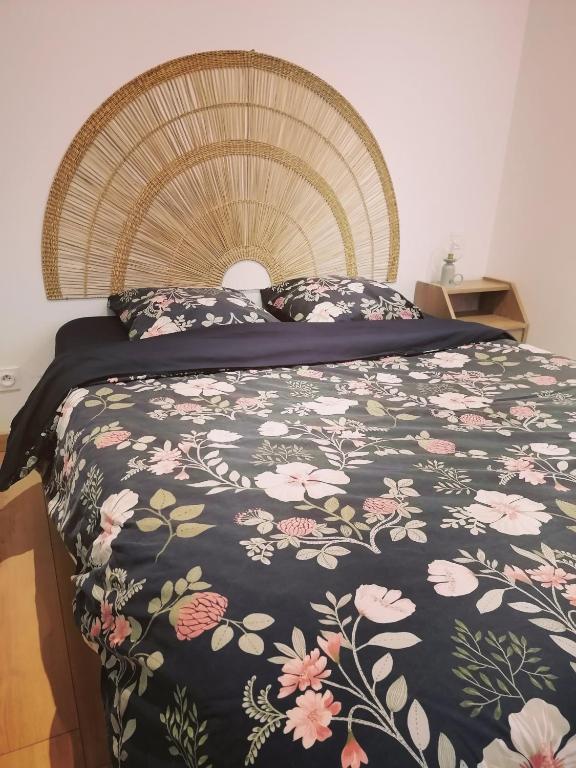une chambre avec un lit avec un couvre-lit fleuri dans l'établissement Charme saint Jean, à Pithiviers