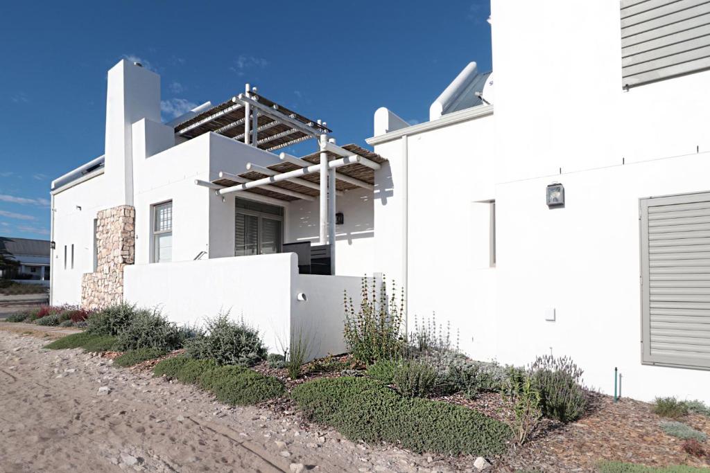 a white house with a fence in front of it at Kestrel Apartments in Paternoster