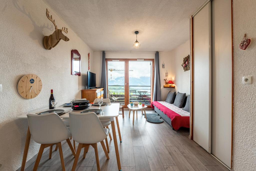 un salon avec une table, des chaises et un canapé dans l'établissement Le Nid des Marmottes - Appt proche station de ski, à Villarembert