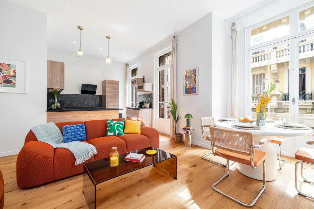 a living room with a couch and a table at Soleil de la Buffa - Un joyau central à 3 min des plages in Nice