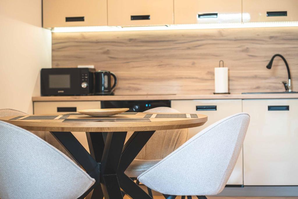 Una cocina con una mesa y sillas en una cocina. en Emila's apartments, en Palanga