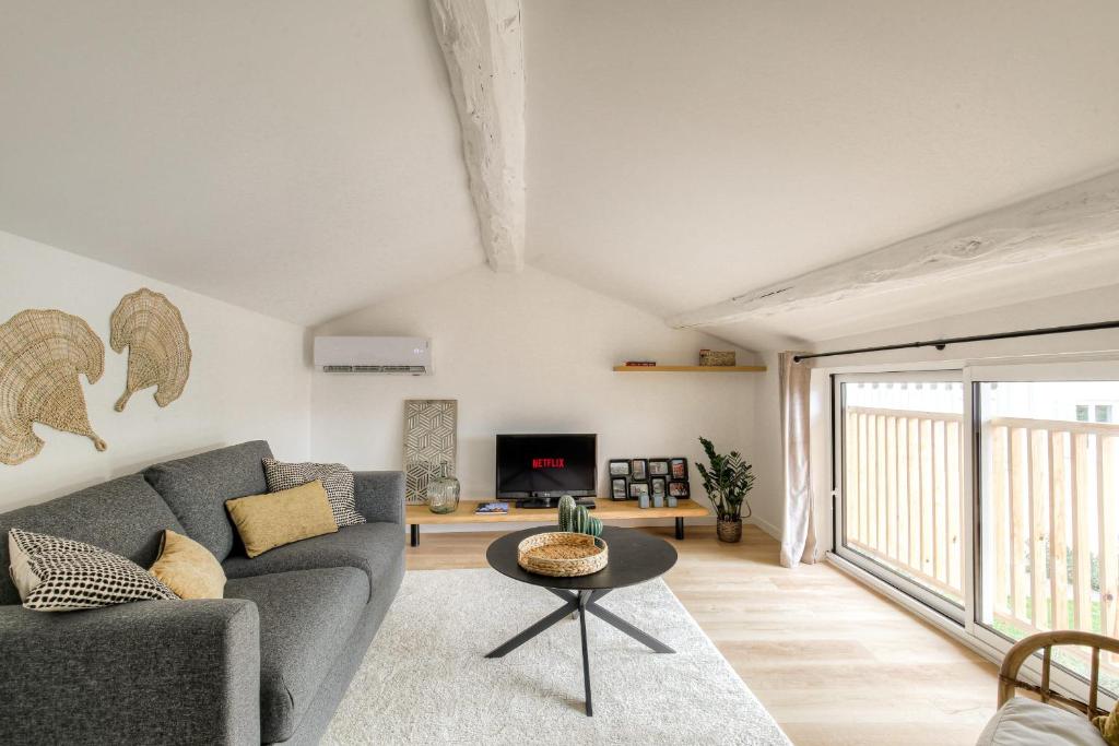 un salon avec un canapé et une table dans l'établissement Le chaleureux et cosy proche Lyon, à Les Rivages