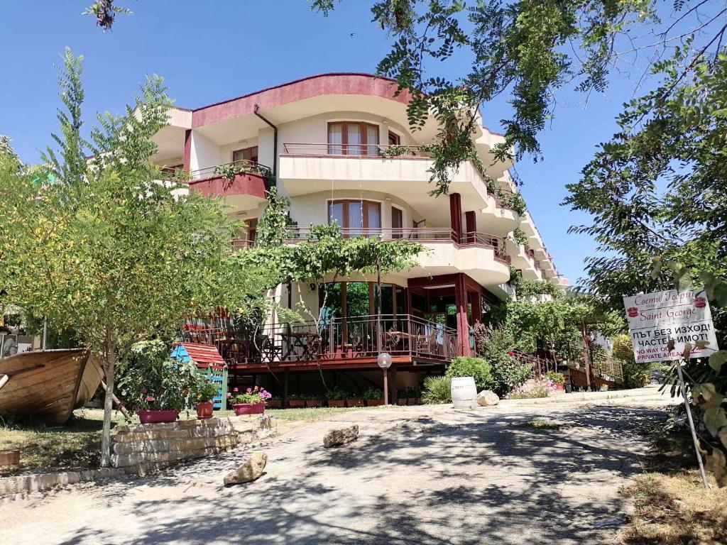 a large building with trees in front of it at St. George Guest House in Sveti Vlas