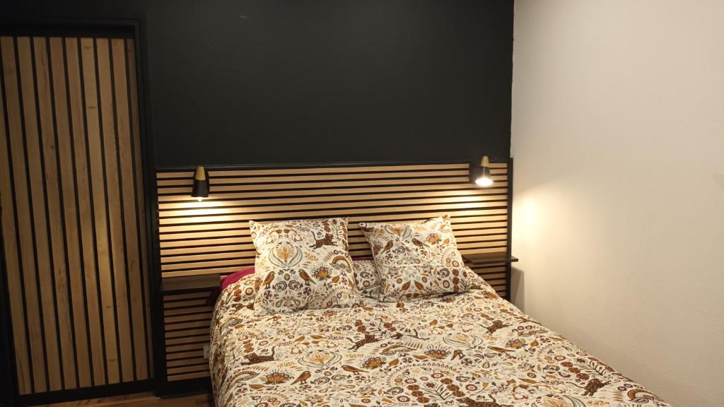 une chambre avec un lit avec des oreillers dessus dans l'établissement superbe appartement T2 proche de vulcania, à Pontaumur