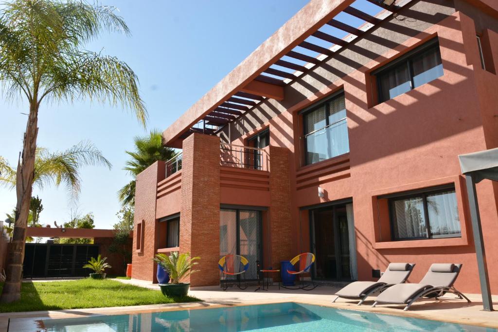 a house with a swimming pool in front of it at Atlas Royale Marrakech in Marrakesh