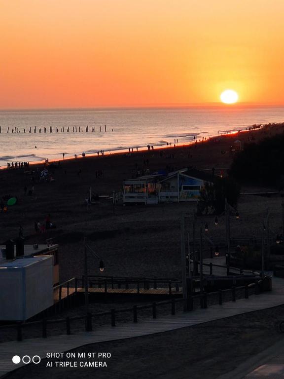a sunset on a beach with people on the beach at Balcón del Mar in Monte Hermoso