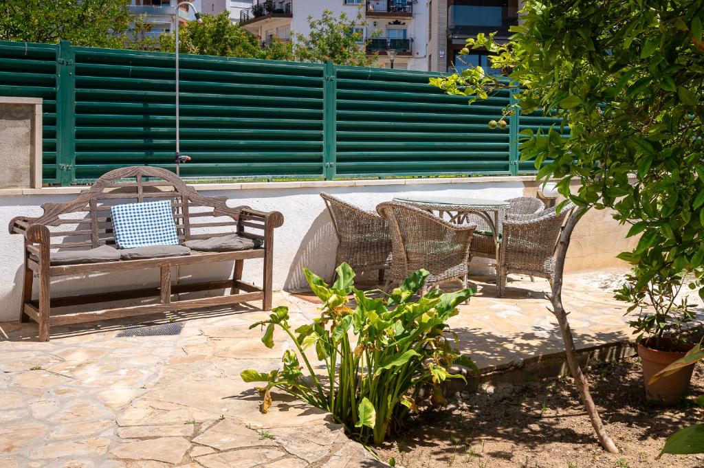 deux chaises en osier assises sur une terrasse à côté d'un arbre dans l'établissement AT077 Planta baja con jardín privado, à Torredembarra