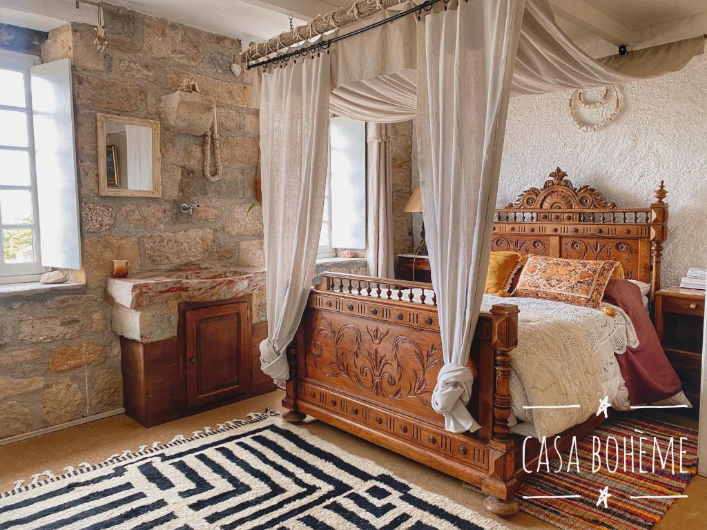 une chambre avec un lit à baldaquin et un miroir dans l'établissement Casa Bohême, à Caunes-Minervois