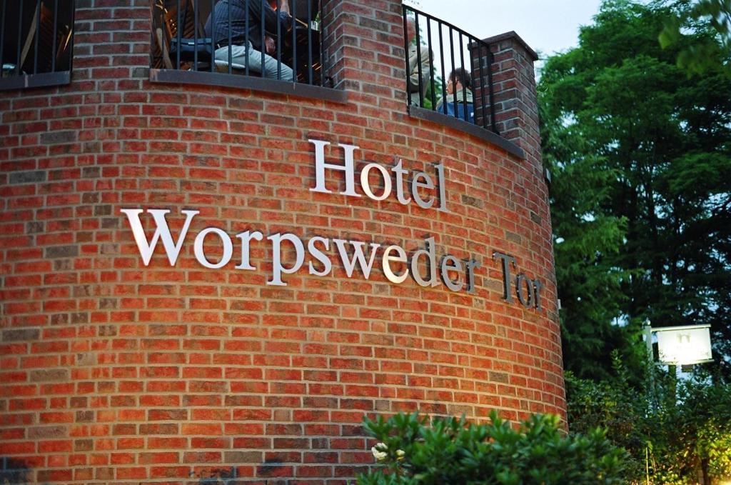 eine Backsteinmauer mit den Worten hotelwocomuseumdir in der Unterkunft Hotel Worpsweder Tor in Worpswede