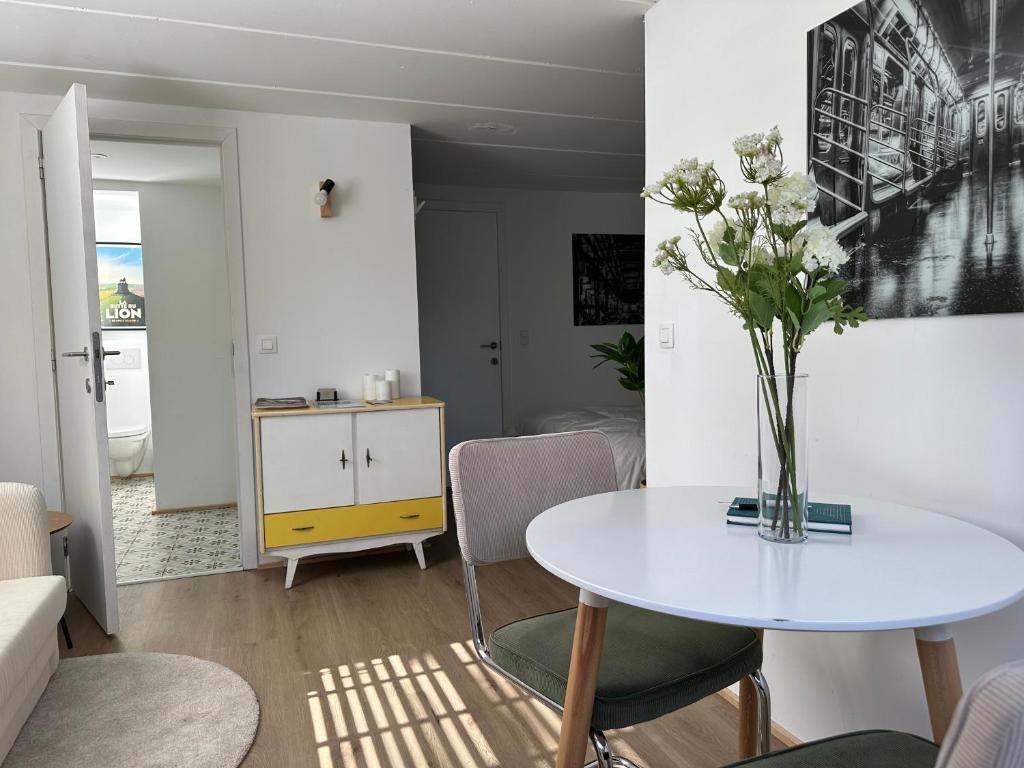 a living room with a table with a vase of flowers at Le Cottage in Lasne