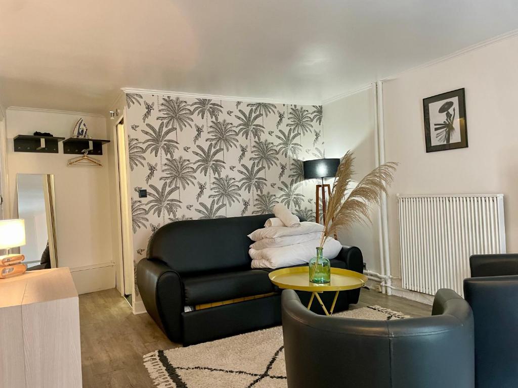 un salon avec un canapé en cuir noir et une table dans l'établissement Elegant Triplex - Tour Eiffel Invalides, à Paris