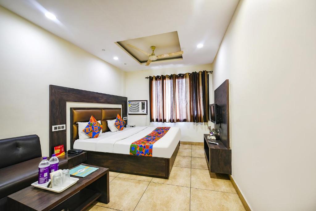 a hotel room with a bed and a couch at FabHotel Nanda Civil Lines in Ludhiana