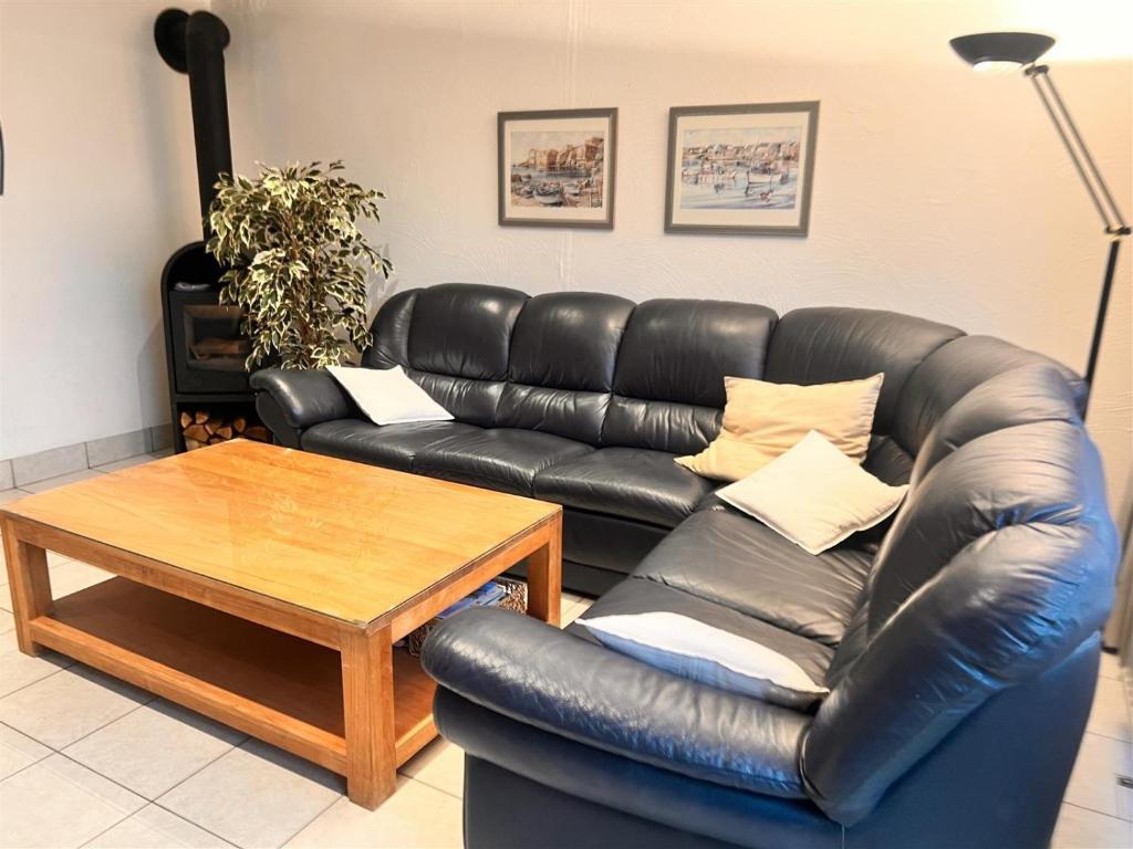 a living room with a leather couch and a table at Barkas 18 in Nieuwpoort