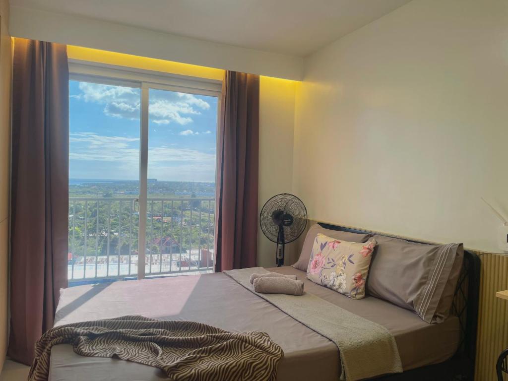 Un dormitorio con una cama con una ventana grande. en work & chill 깨끗한 compact studio, en Lapu Lapu City