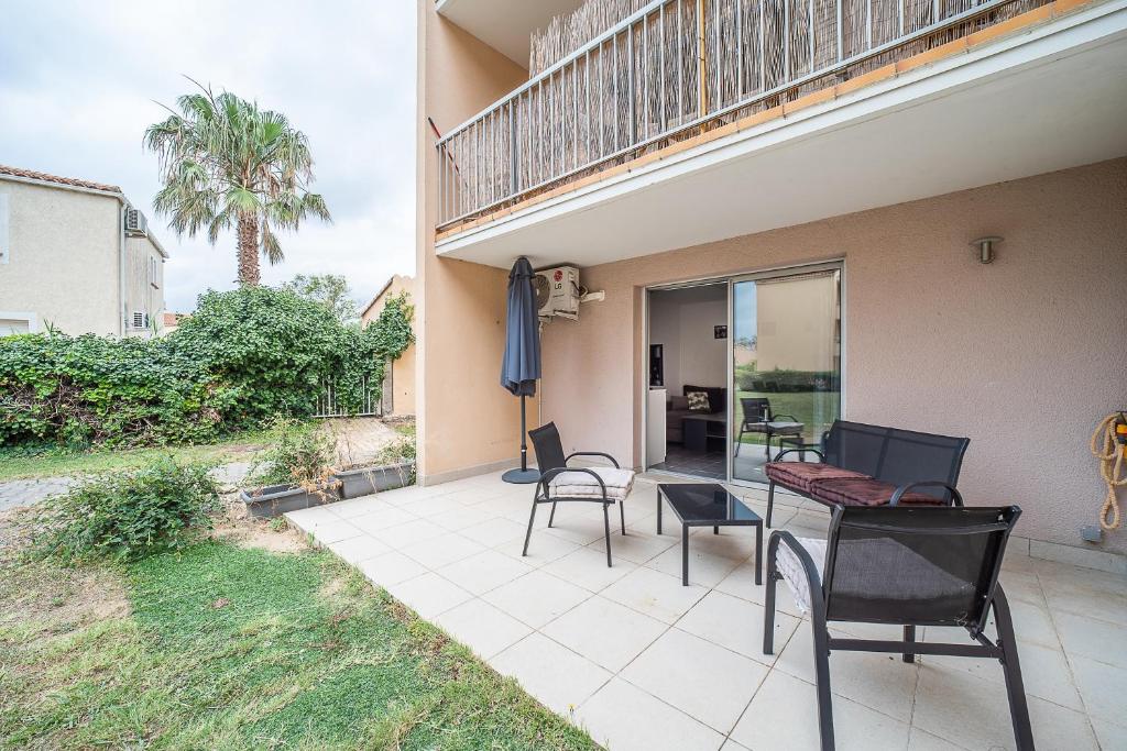 d'une terrasse avec des chaises et des tables ainsi que d'un balcon. dans l'établissement Le Cosy Canétois - A 20 min de la plage, à Canet