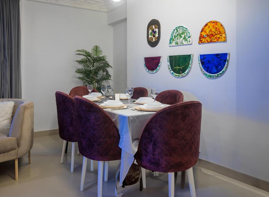 a dining room with a table and purple chairs at Skyline Premium Properties in Alexandria