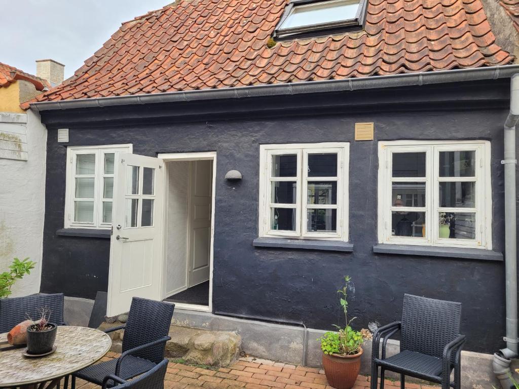 a black and white house with a table and chairs at Skrædderens Baghus in Assens