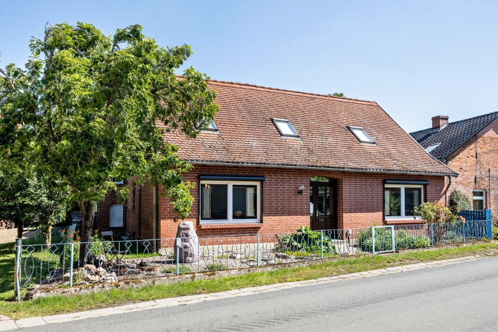 a brick house with a fence in front of it at Kleines Glück in Seedorf