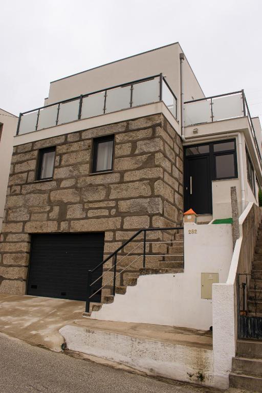 a brick building with a garage and stairs at Casa do Barreiro in Baião