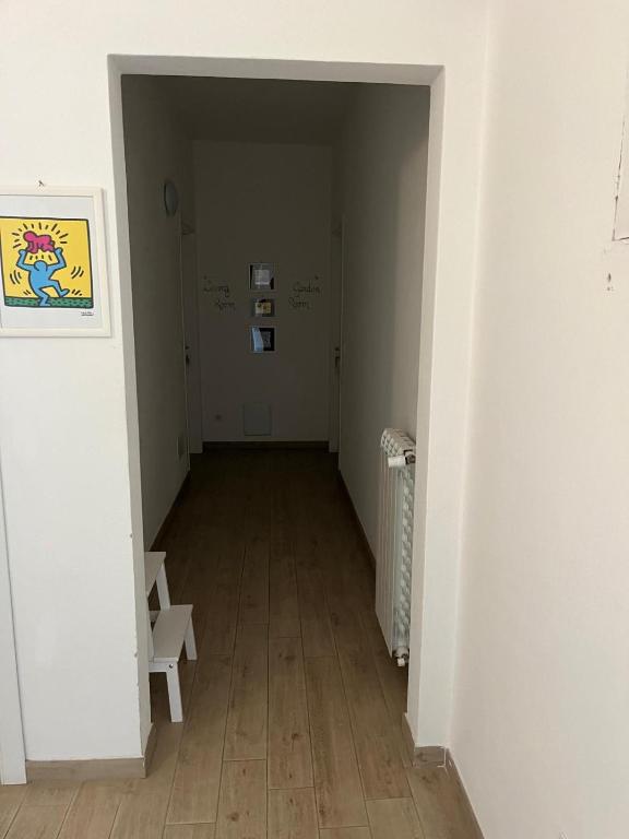 an empty hallway with white walls and wooden floors at My Bnb Pisa in Pisa