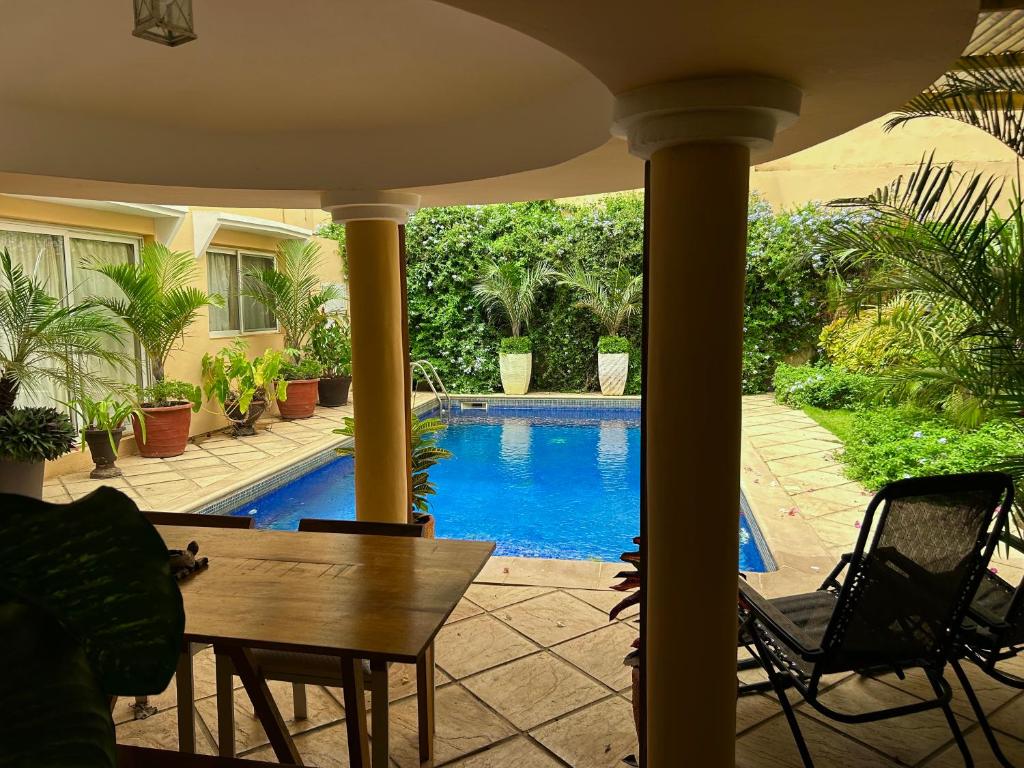 a patio with a table and a swimming pool at Two bedroom villa with private swimming pool and garden in Almadies in Dakar
