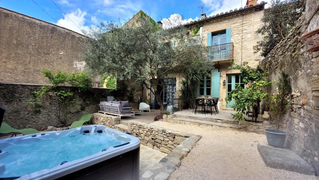 un bain à remous extérieur dans une cour à côté d'un bâtiment dans l'établissement Ancienne Maison de Vigneron avec Jacuzzi - Uzès, à Sanilhac-et-Sagriès