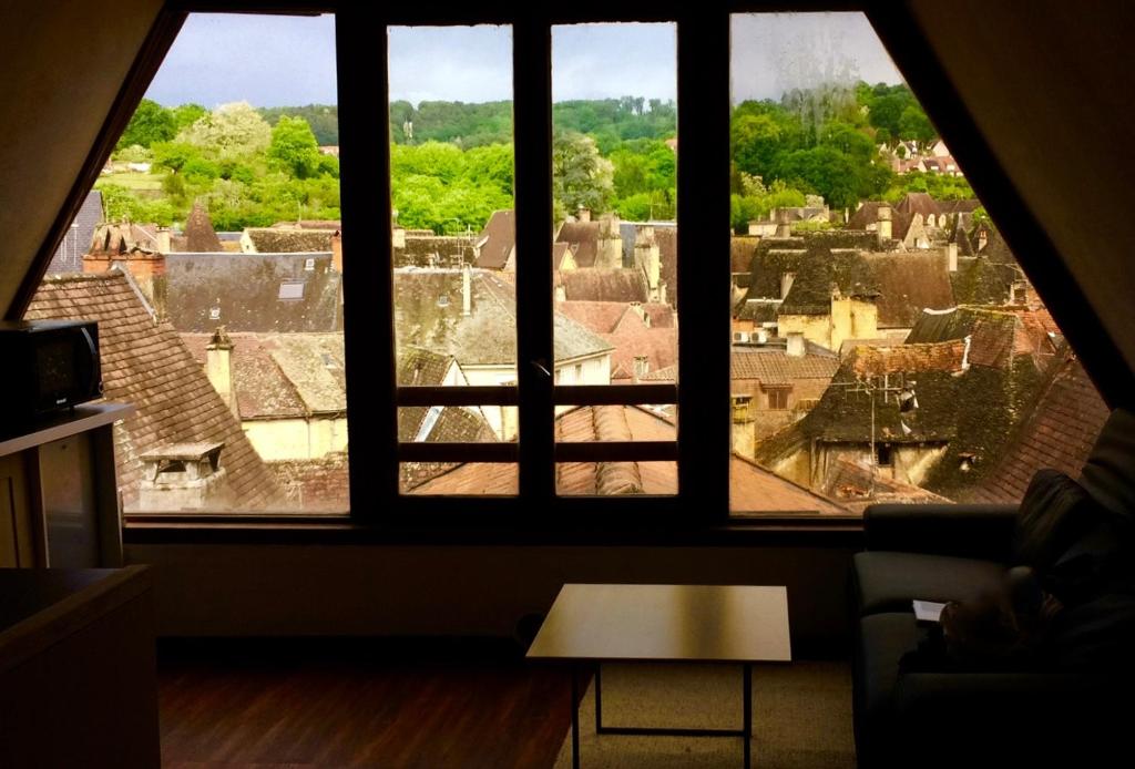 a room with a view of a city from a window at Appartement la Belle Vue Panoramique in Sarlat-la-Canéda