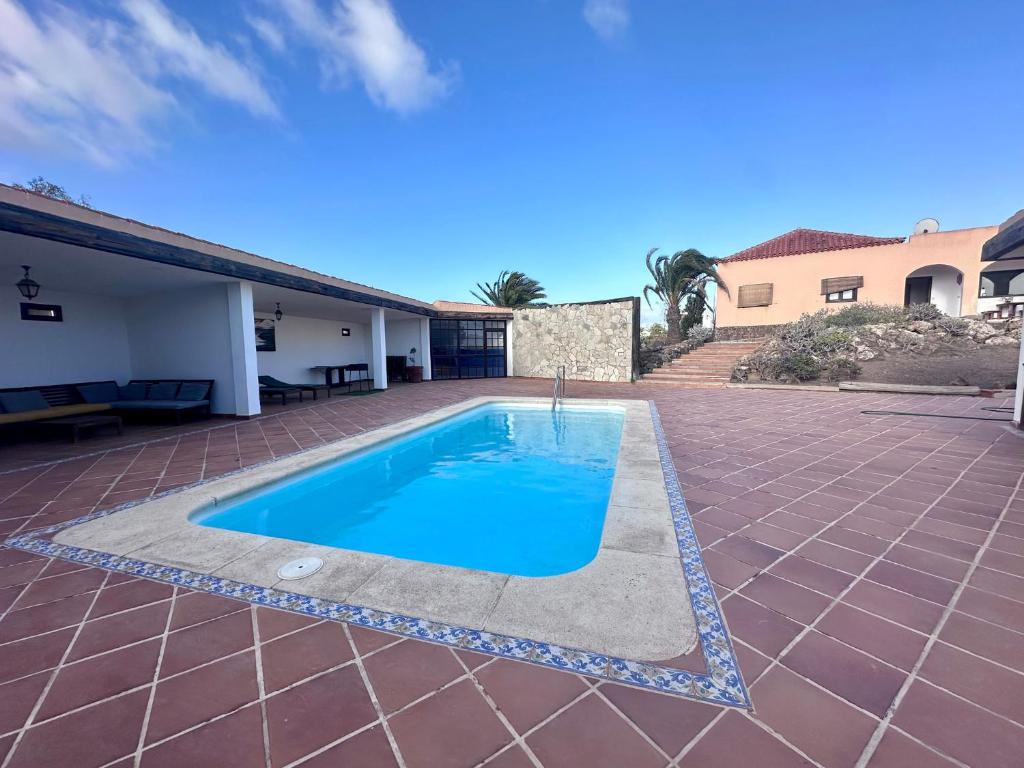a swimming pool in the middle of a yard at Dreamwaves Surf House Fuerteventura in La Oliva