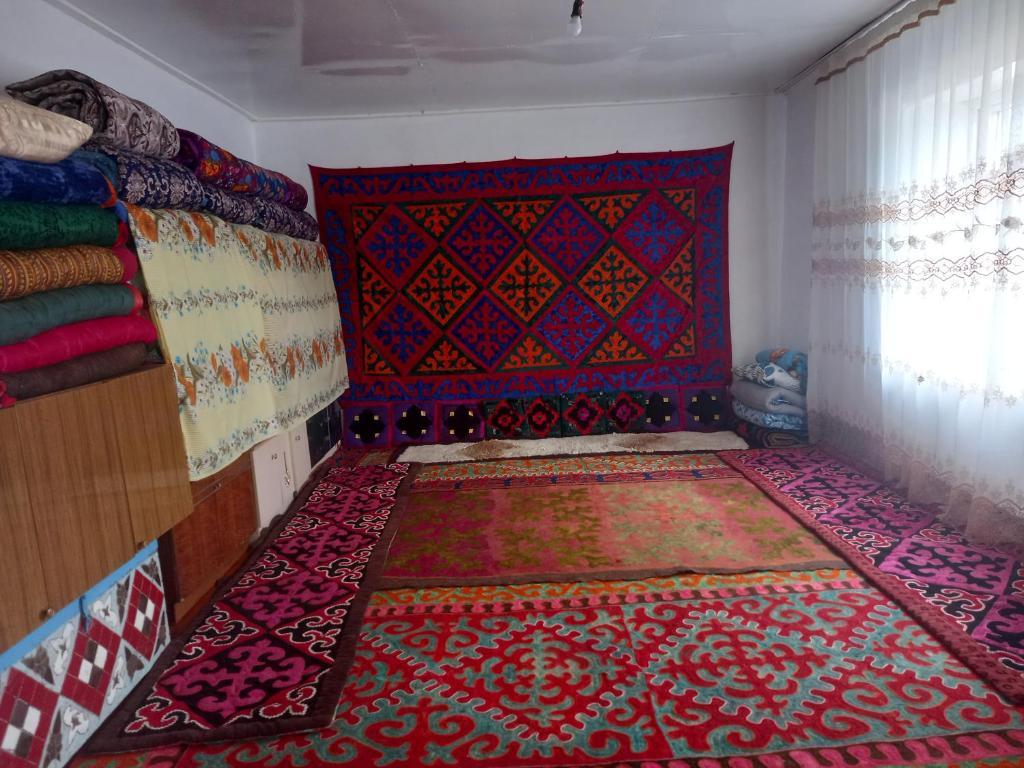ein Zimmer mit einem rot-blauen Teppich an der Wand in der Unterkunft Акбермет in Bokonbayevo